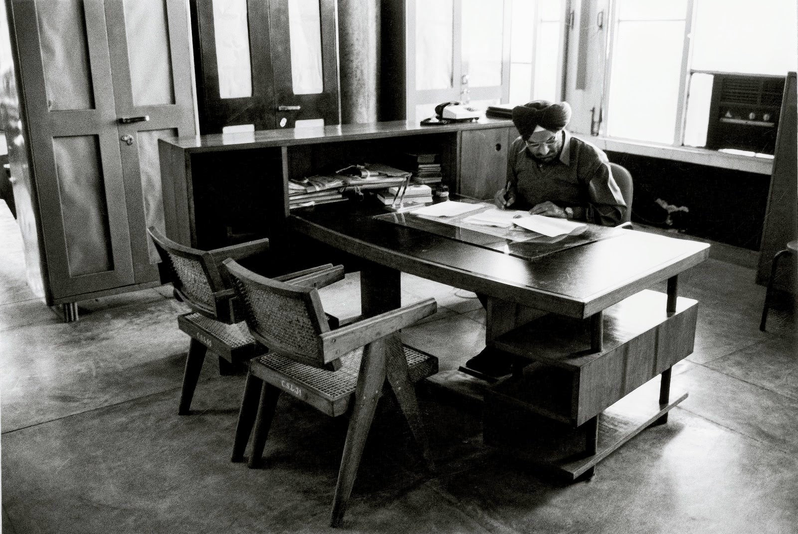 Indian-official-working-at-office-with-Pierre-Jeanneret-furniture-in-Chandigarh